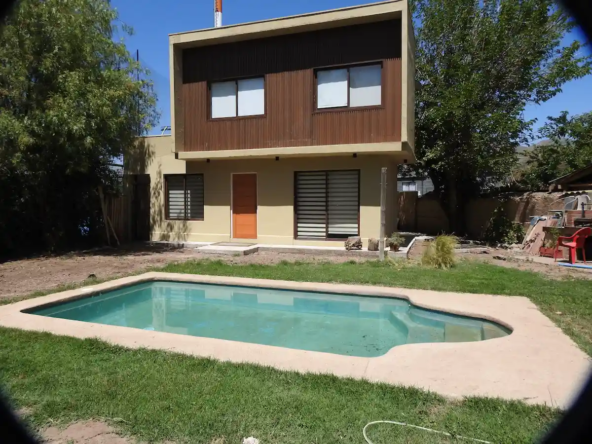 Parte trasera de casa Rinconada de Los Andes, con jardín y piscina