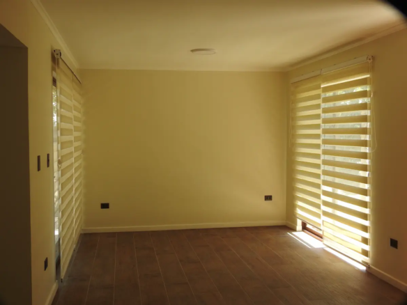 Living de casa Rinconada de Los Andes con dos ventanales y cortinas roller dúo